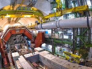 Engineers supervise lowering the magnet onto the wheeled transporter. (Image: CERN)