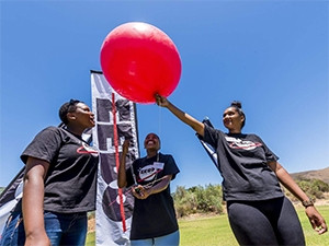 STEM candidates release a weather balloon attached to a CricketSat.