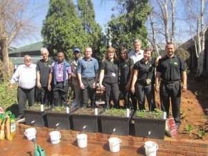 Eddy Gordon of Bytes Document Solutions (second from left) and the Green Team standing behind the earth boxes for growing herbs and vegetables.
