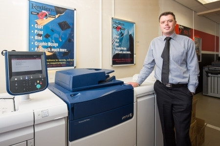 Financial director of Redfern Labels, Steven May, standing alongside the Xerox Versant 80 press