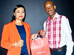 Leeya Hendricks, Marketing Director at Oracle, hands over the IaaS Survey prize to lucky prize winner Mmoni Thekiso.