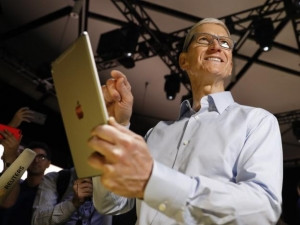 Apple CEO Tim Cook holds the updated iPad.
