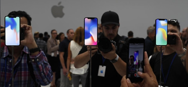 Launch attendees take photographs of the new Apple products.