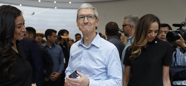 Apple CEO Tim Cook demonstrates a new iPhone after the presentation.