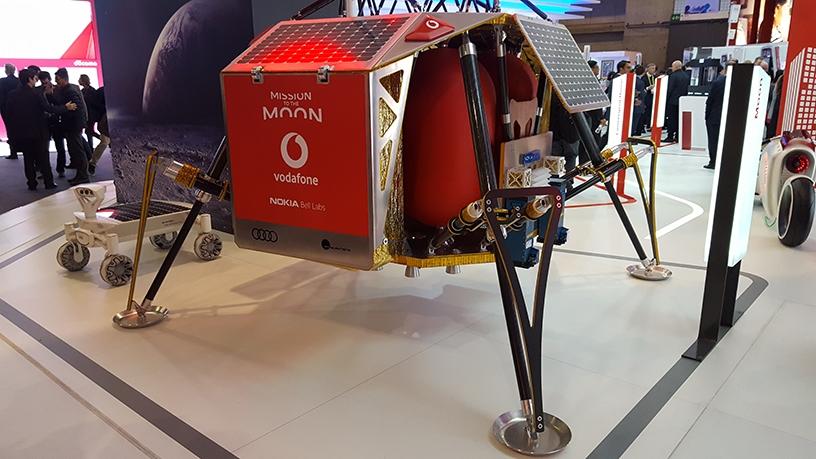 The Autonomous Landing and Navigation Module on display at Vodafone's MWC booth, with the Audi lunar quattro rover in the background.