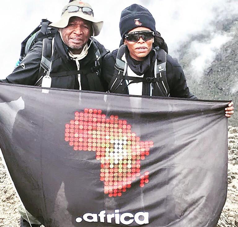 .africa ambassador Unathi and CEO Lucky Masilela hoisting the .africa flag atop the highest peak in Africa Mt. Kilimanjaro.