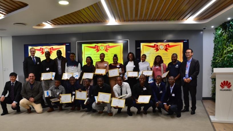 The students show off their certificates while joined by Huawei executives.