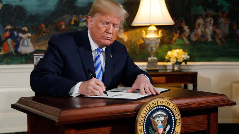 President Donald Trump signs the proclamation declaring his intention to withdraw from the Iran nuclear agreement.