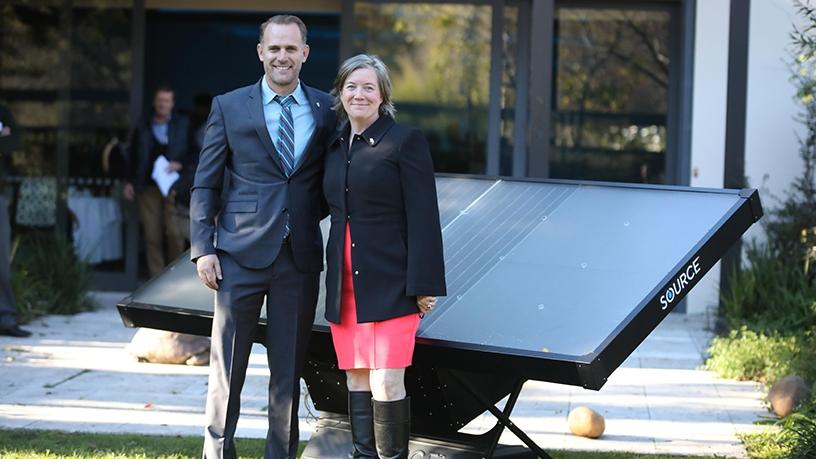 Cody Friesen, Zero Mass Water CEO, and US consul general, Virginia Blaser, in front of an array of SOURCE Hydropanels at the Vineyard Hotel in Cape Town.